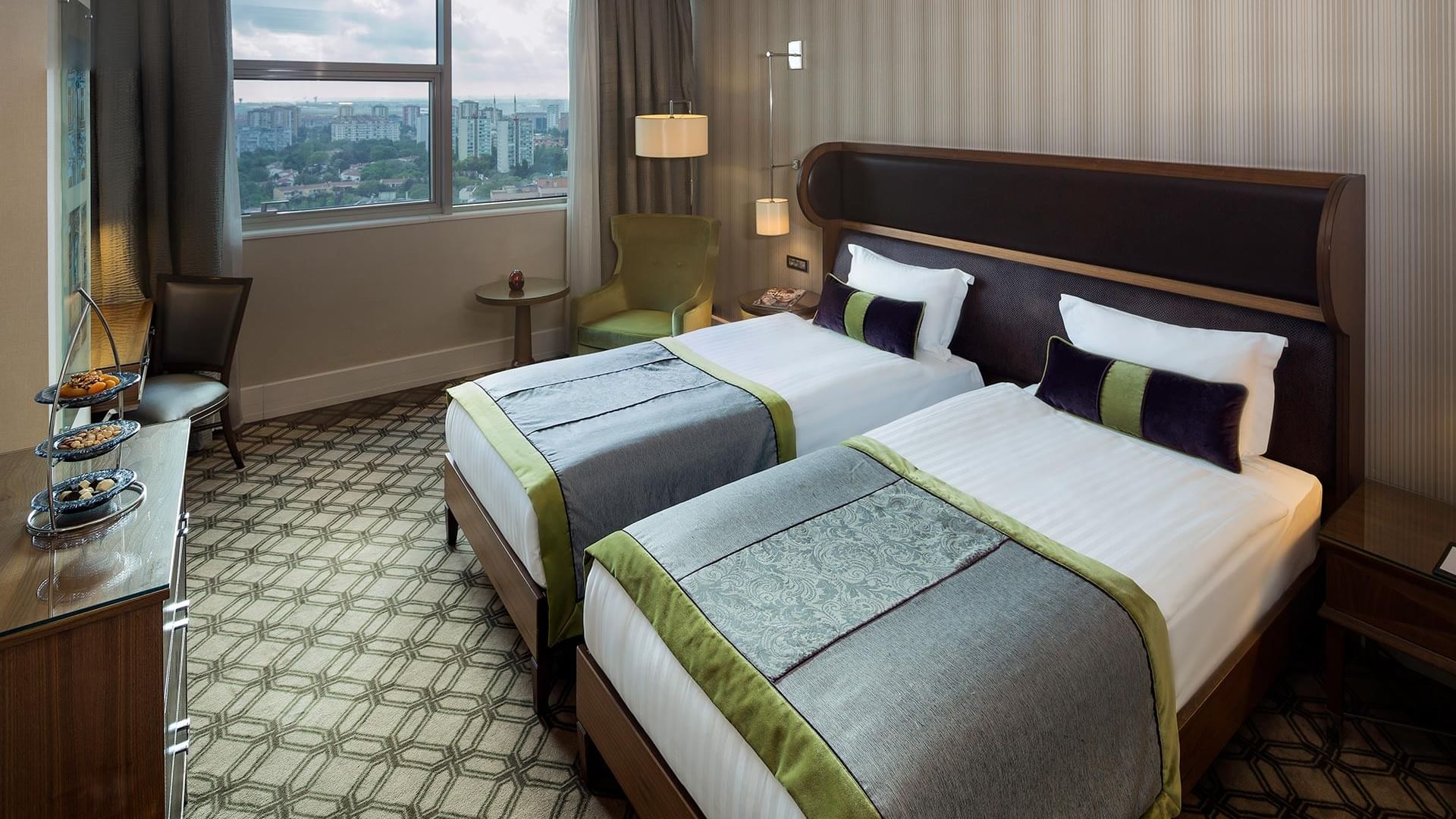 Titanic Port Bakırköy’de, iki yataklı; komodinler, koltuklar ve penceresinden şehir manzarası görülen Superior oda.