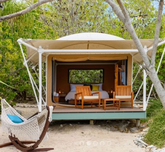 Outdoor setup with a hammock and chair placed in front of the Resort tent