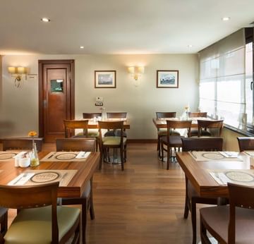 Titanic Comfort Şişli’nin Alesta Restaurant’ı, sıcak atmosferiyle ahşap yemek masaları ve konforlu sandalyelerden oluşan şık bir yemek alanı sunar.