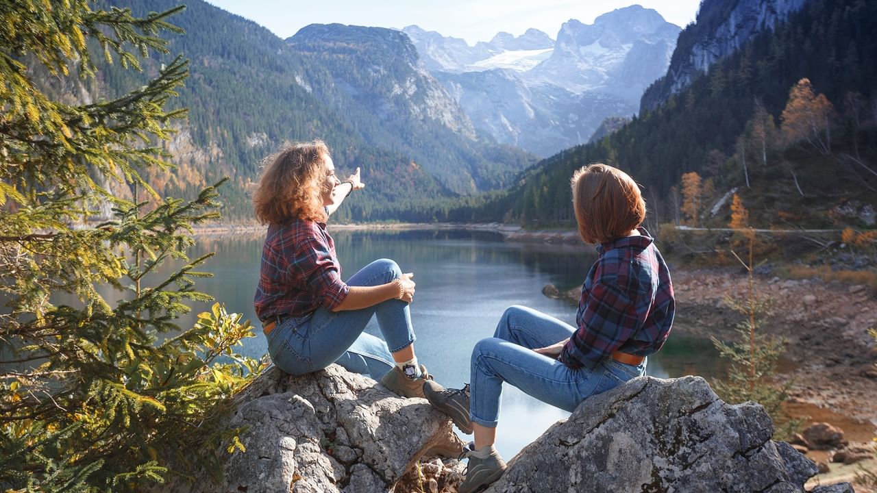two women enjoying mountain lake scenery