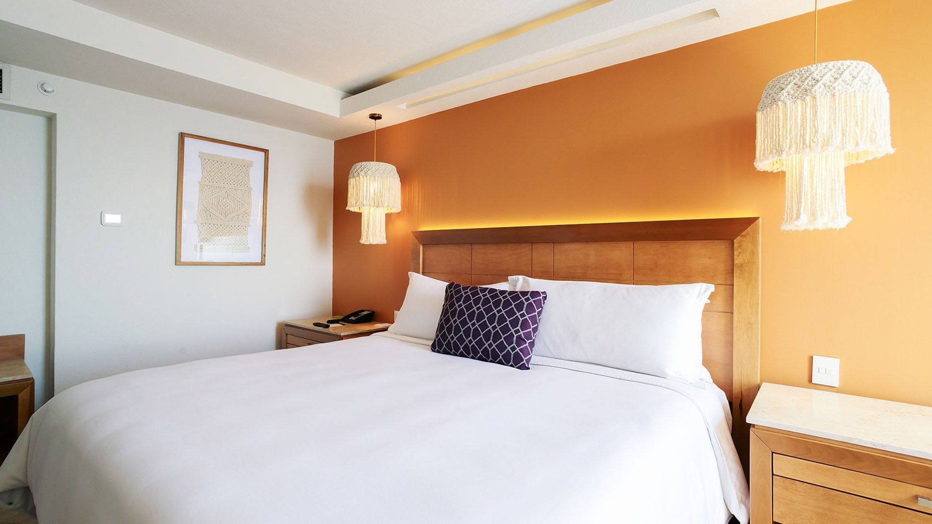 King Deluxe Superior bedroom detail featuring a wooden headboard and unique macrame light fixtures at Camino Real Veracruz