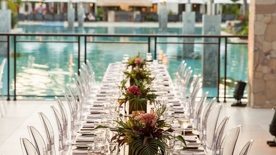 Outdoor wedding set up with long dining table by the pool in Lagoon View Terrace at Pullman Port Douglas