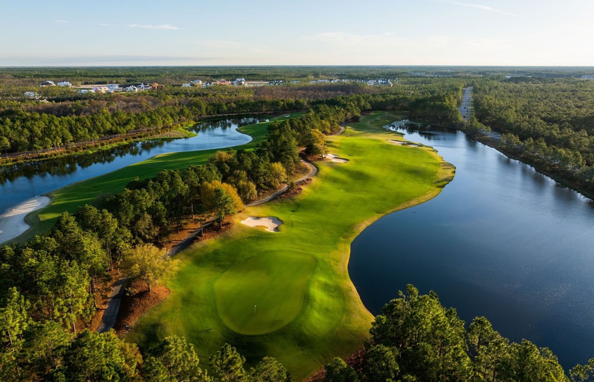 Aerial view of a golf course with lush greenery and water features at Camp Creek Inn