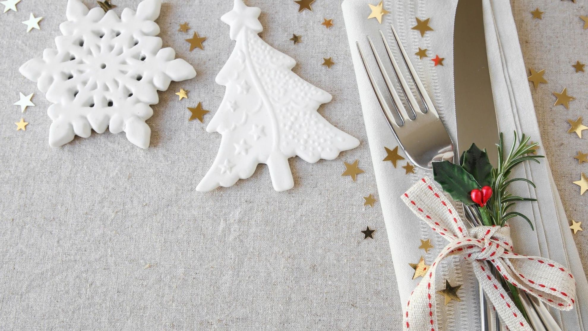 Festive In-Villa Indulgence with snowflakes, Christmas tree, stars, and decorated cutlery on a napkin.