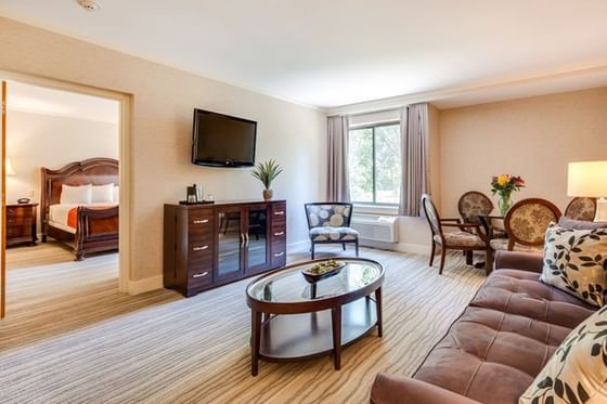 Spacious executive suite living room with a sofa, dining area, and entrance to a bedroom at Heritage Hotel