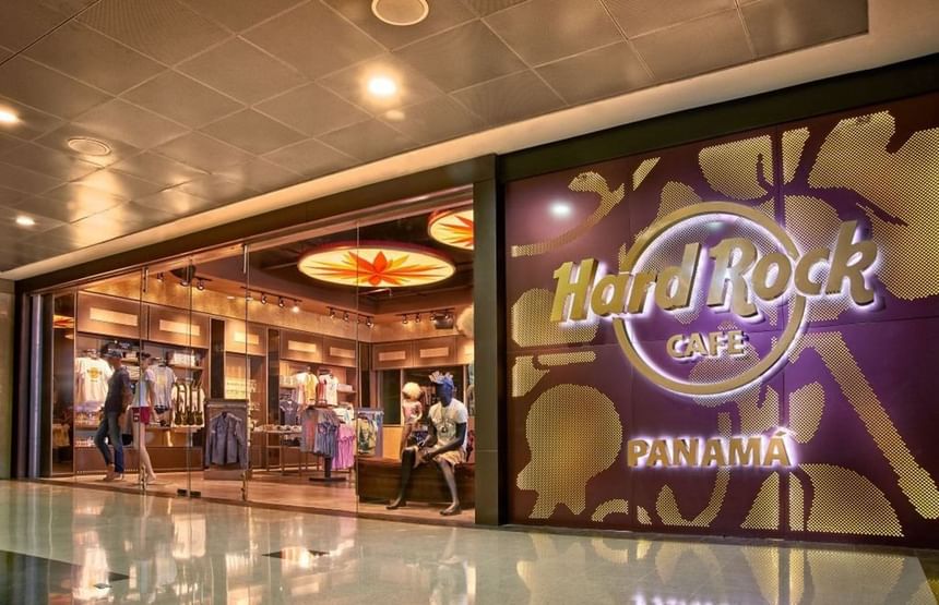 Hard Rock Cafe Panama storefront with glowing gold signage, mannequins in the glass shop at Megapolis Hotel Panama