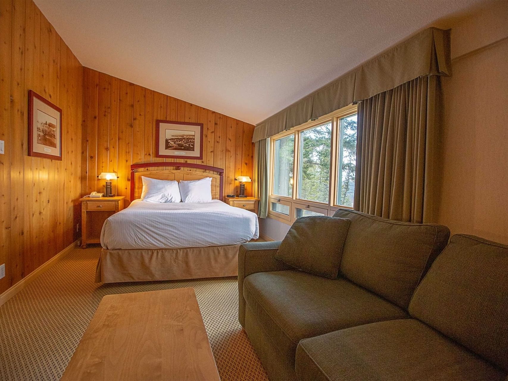 Bed arranged with a cozy sofa in Classic 1 Queen at Fairmont Hot Springs Resort