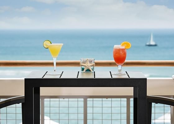 Two cocktails served on a table facing the sea near Meadowmere Resort