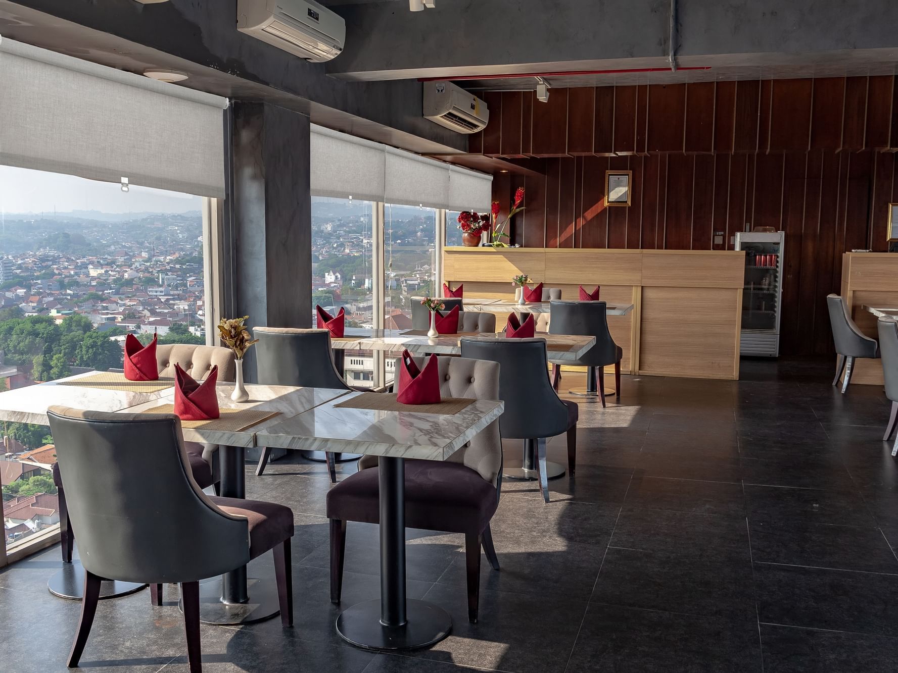 Dining tables and counter with city view in Gastro & Sky Bar at LK Hotel Simpang Lima