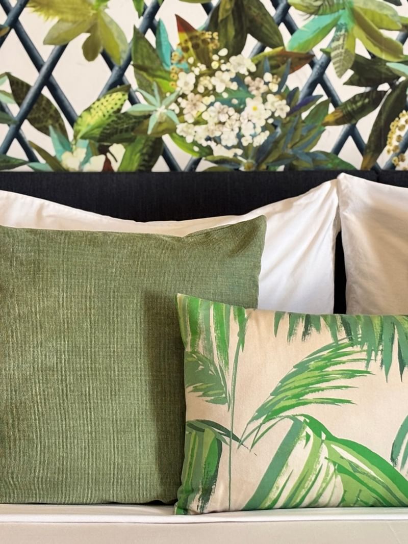 A bed with tropical themed pillows at Warwick Le Lagon - Vanuatu, Efate.