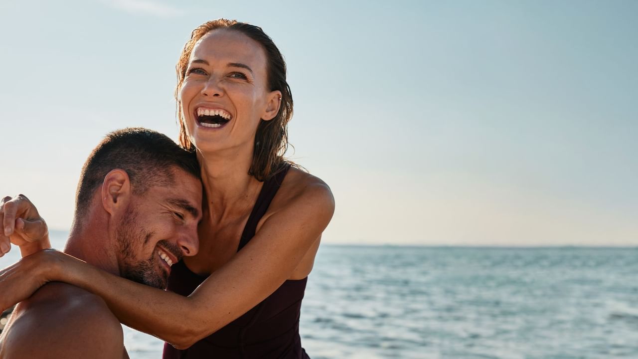 Two people embracing by the sea near Falkensteiner Luxury Villas