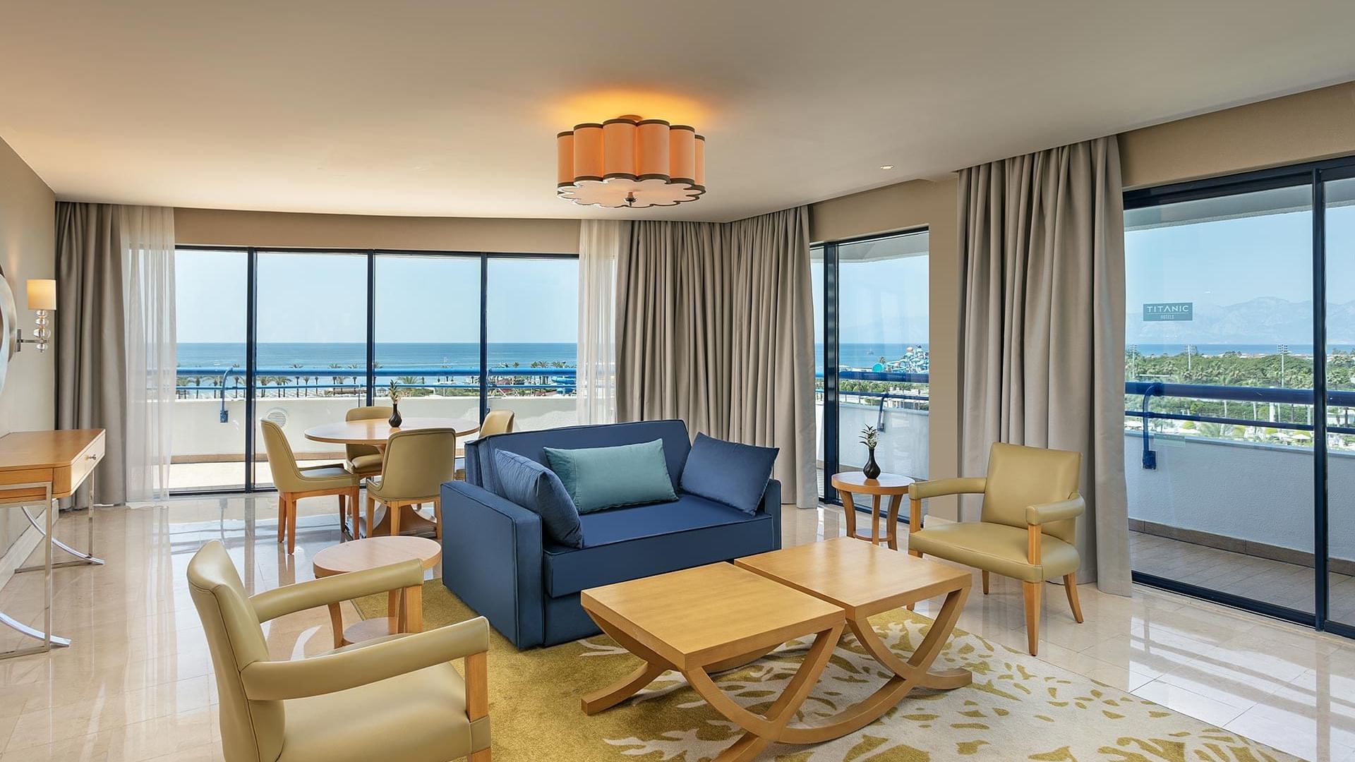 Junior Suite's Living Room with comfy chairs and sea view from the balcony at Titanic Deluxe Lara