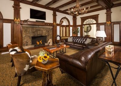 Modern living area of a Ranch Room at The Stanley Hotel with a plush couch fireplace and carpeted floor