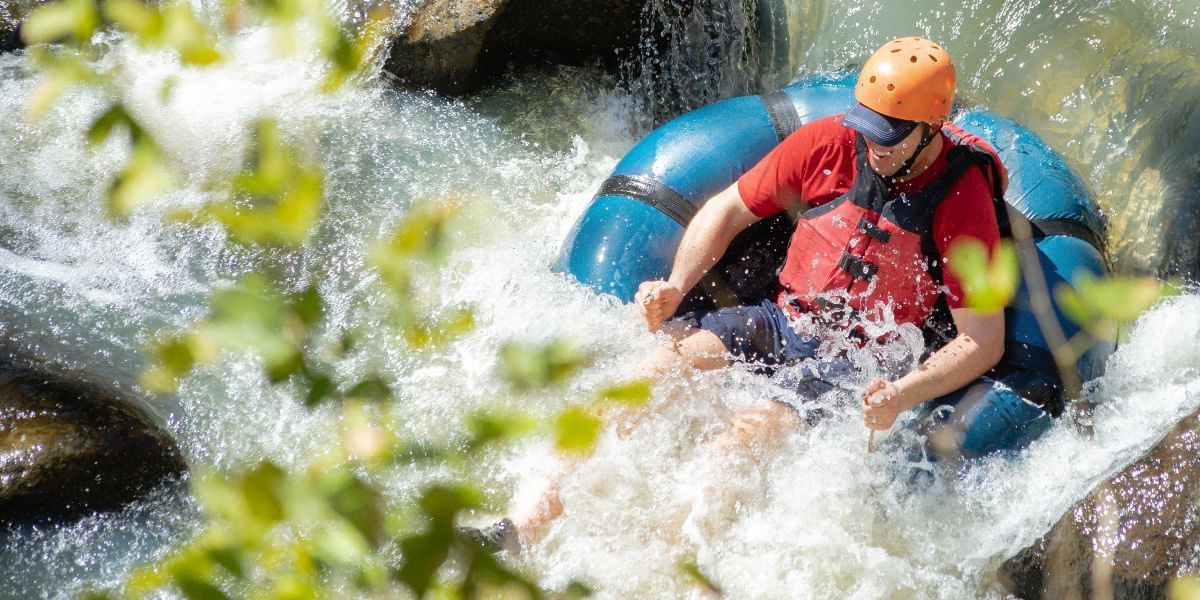 Man enjoying the water tubing experience in the river near Hotel Rio Perdido