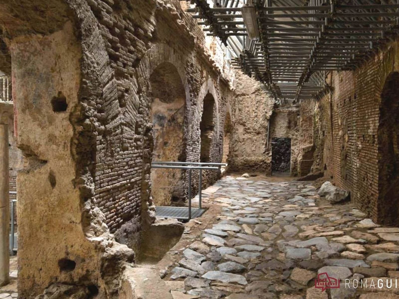 Crypta Balbi stone pathway between weathered brick walls with a metal framework near The Glam Hotel