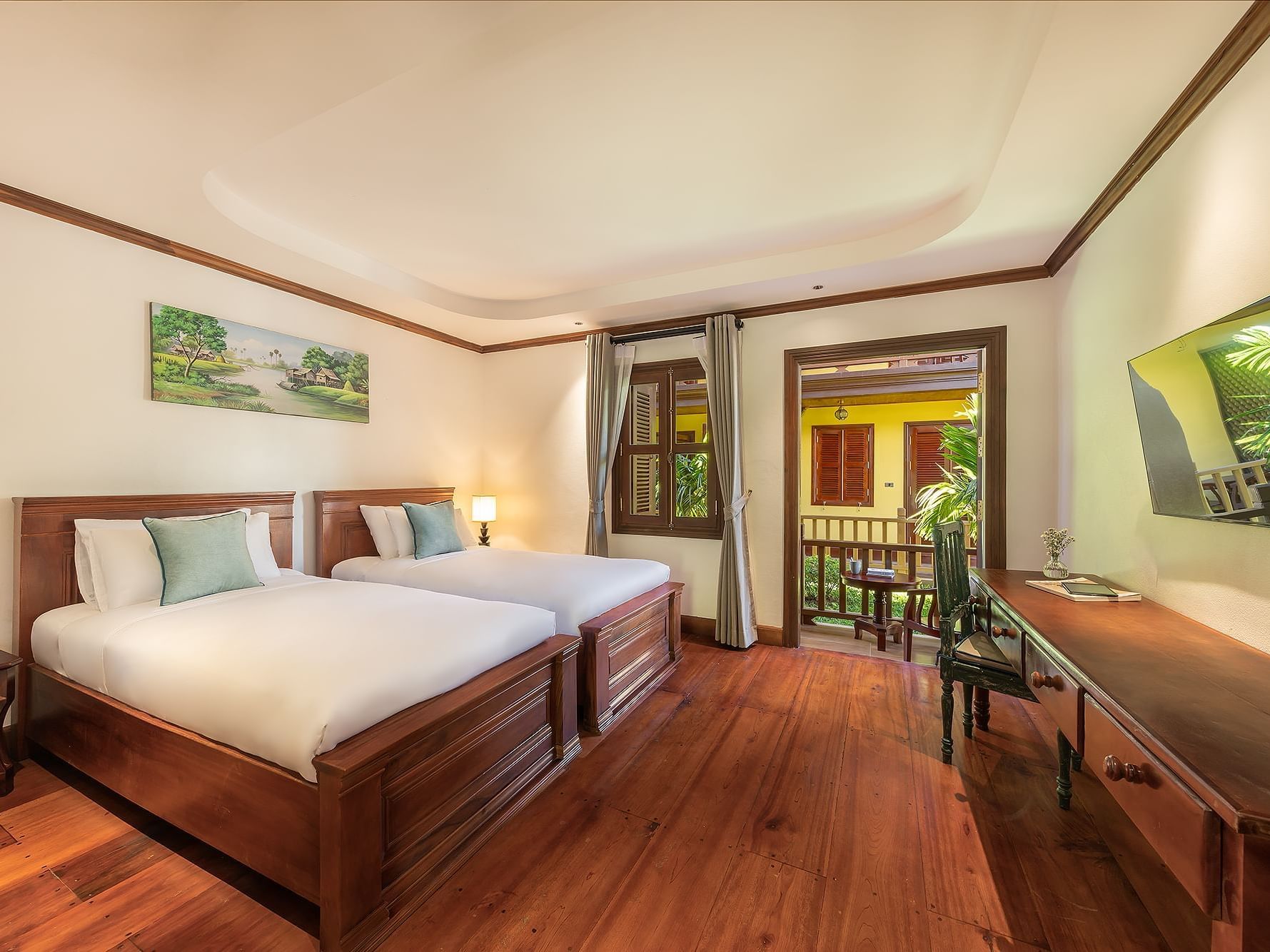 Two beds facing TV and nightstand in Deluxe Garden View with Bathtub at U Luang Prabang