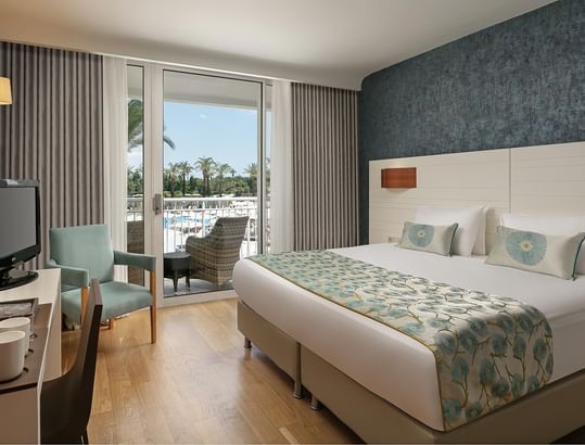 Titanic Deluxe Lara – Annex Family Room’da çift kişilik yataklı, balkonlu ve dekoratif duvarlı şık bir oda.