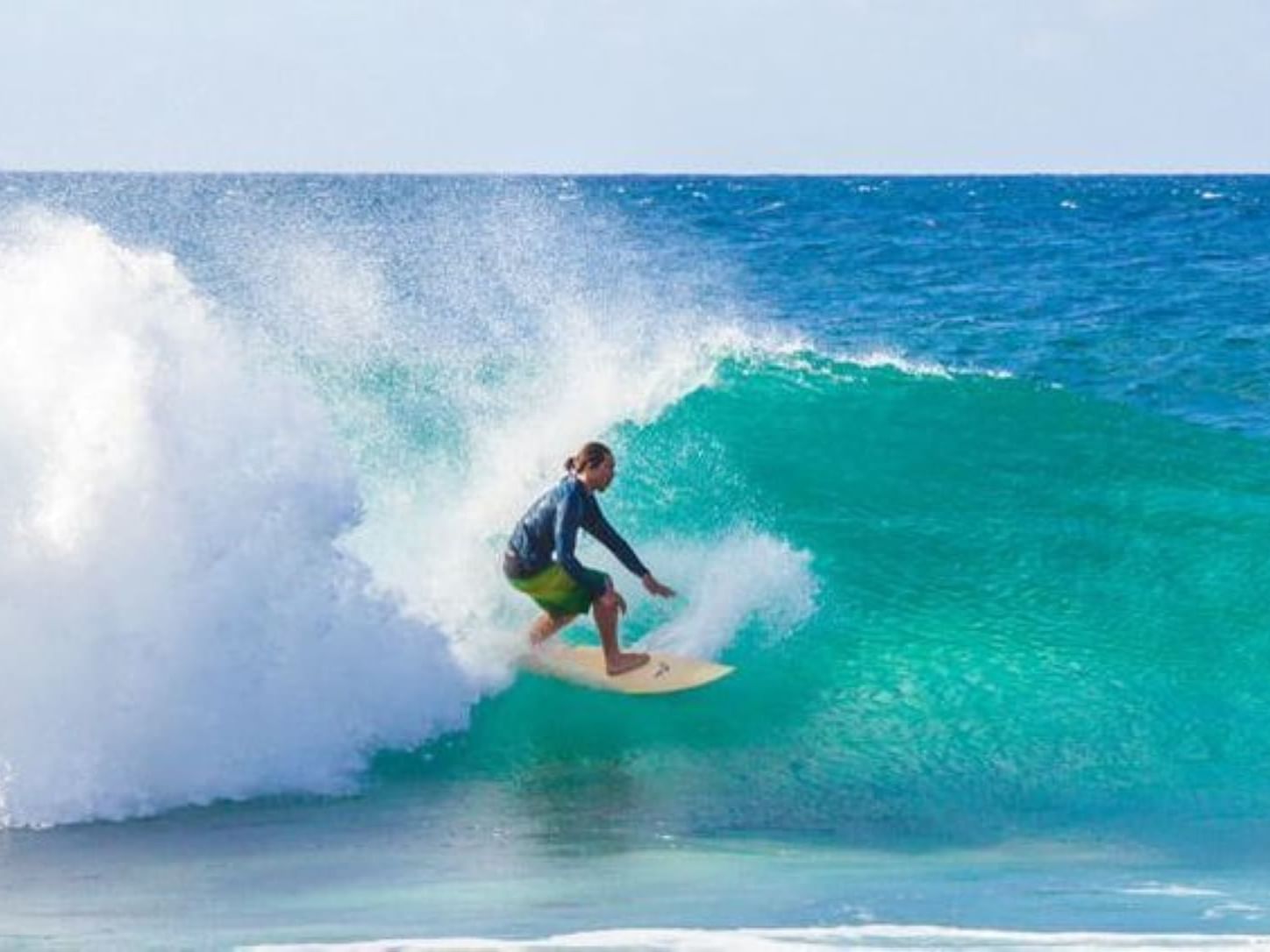 A surfer surfing on the ocean waves near Stay Hotel Waikiki
