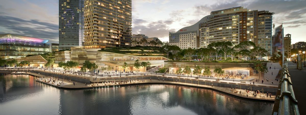Exterior view of Novotel Sydney on Darling Harbour with high-rise buildings and vibrant outdoor spaces along the water's edge