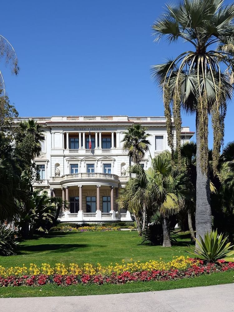 Beautiful historic architecture of Massena Museum surrounded by lush palm trees near Splendid Hotel & Spa Nice