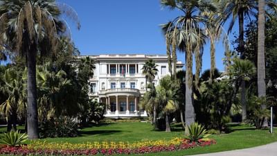 Beautiful historic architecture of Massena Museum surrounded by lush palm trees near Splendid Hotel & Spa Nice