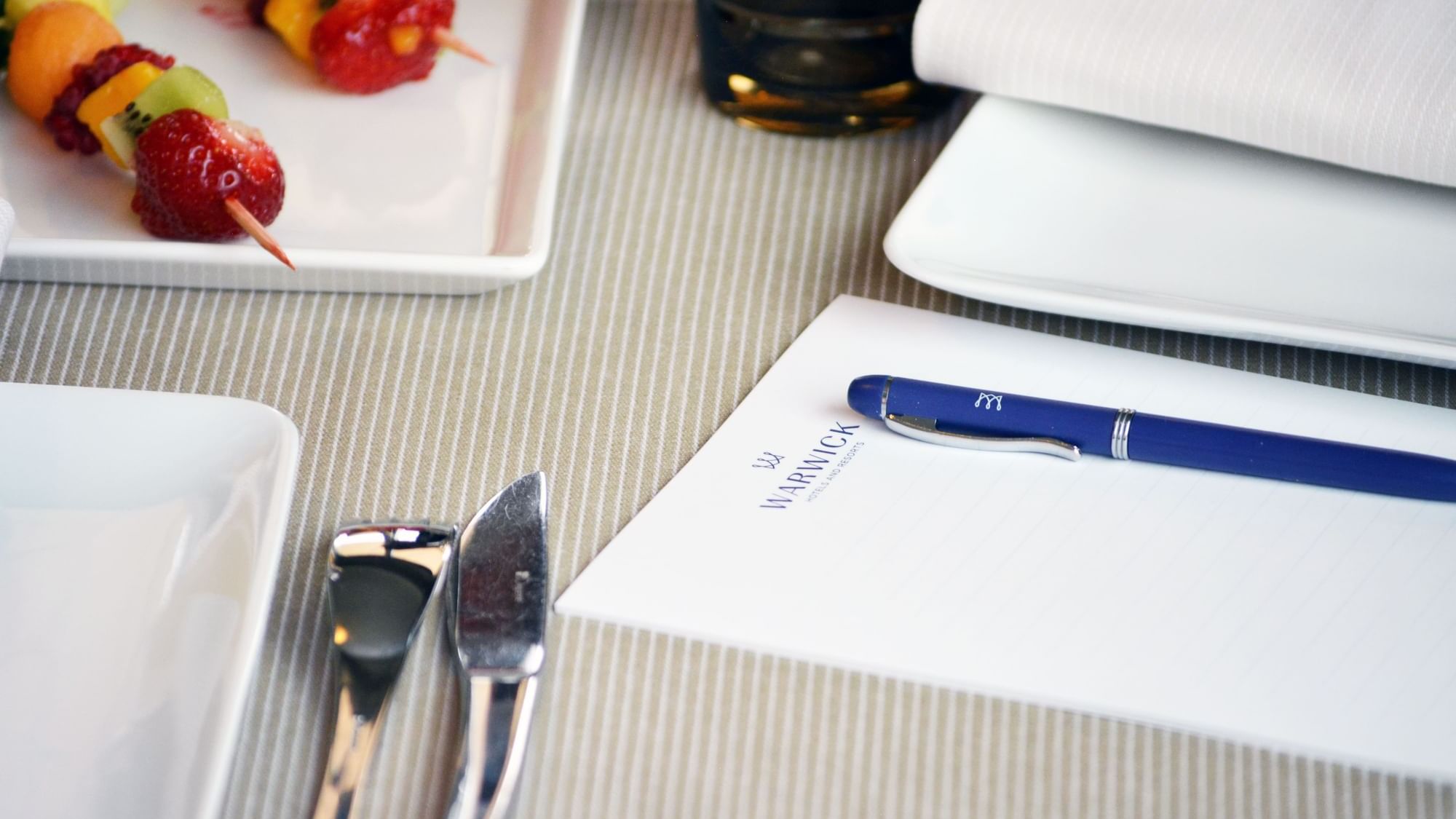Close-up of table with notebook and pen at Warwick Paris Champs Elysées