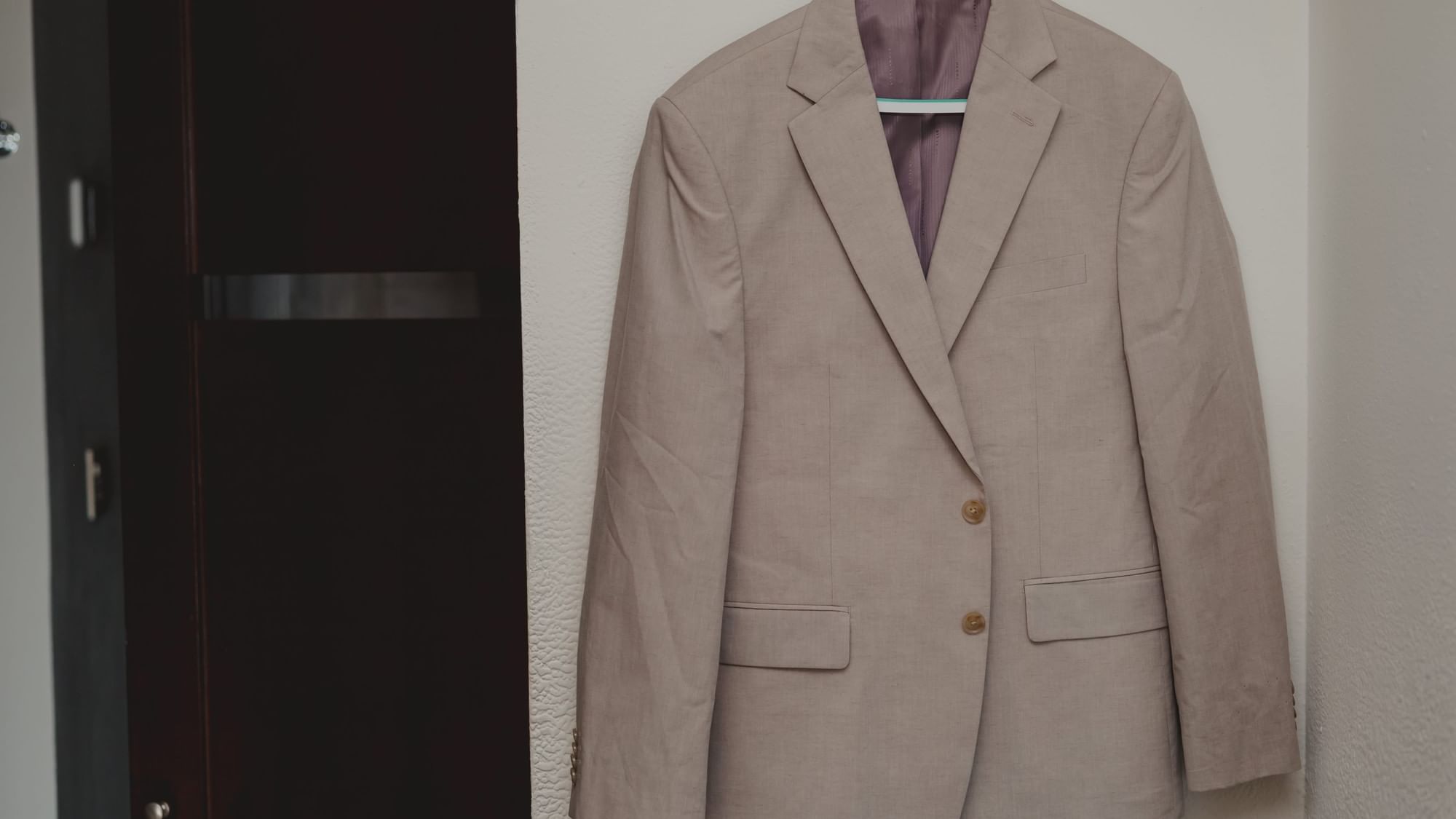 Beige suit jacket hanging on a white wall at Fiesta Americana Riviera Nayarit Resort & Spa.