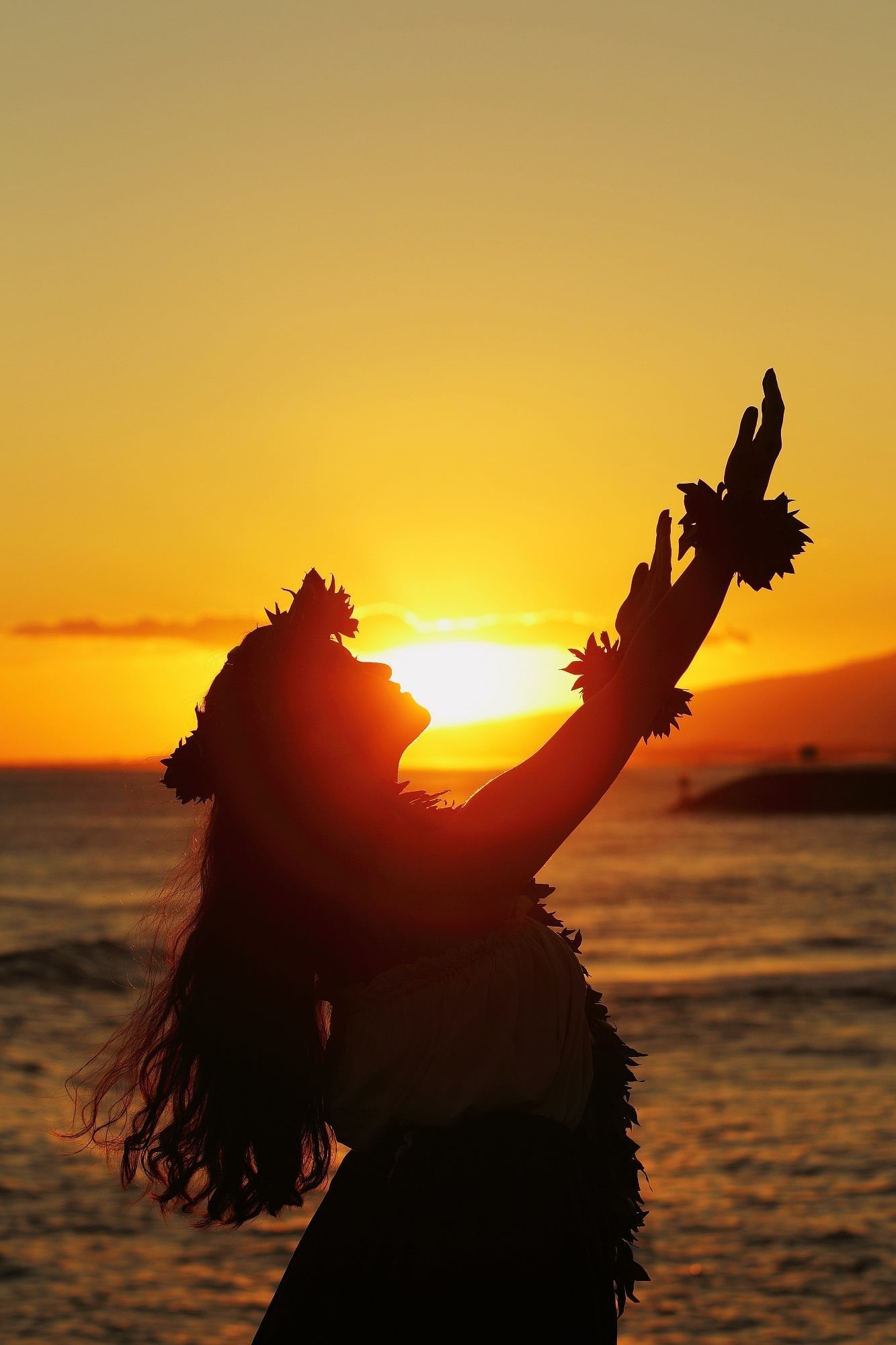 A lady with a village costume and doing a cultural dance in Makapu'u Beach near Waikiki Resort Hotel