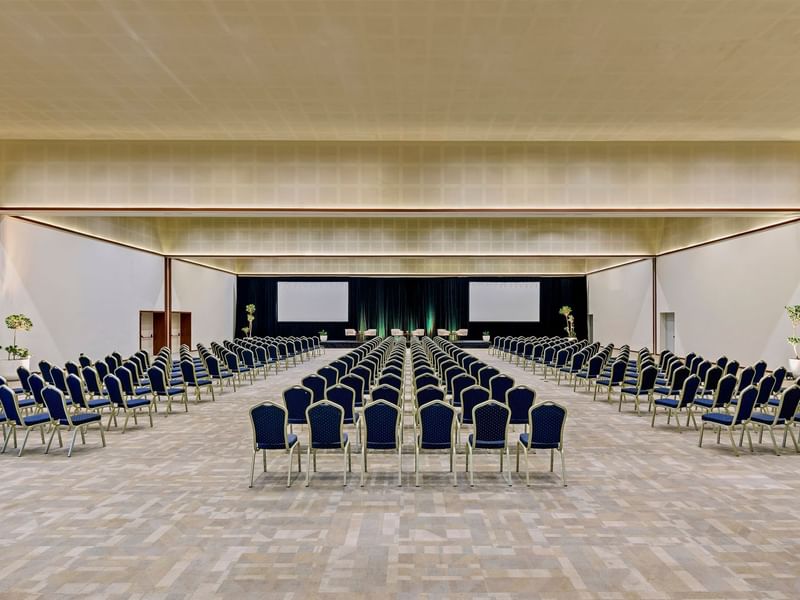 Theatre set-up in a spacious event hall with carpeted floors at Live Aqua Resorts and Residence Club