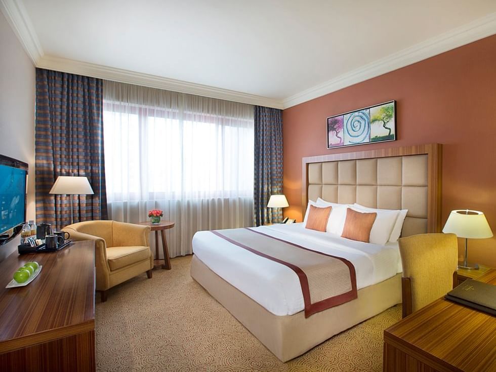 King bed with a TV in Premium Room at City Seasons Hotels