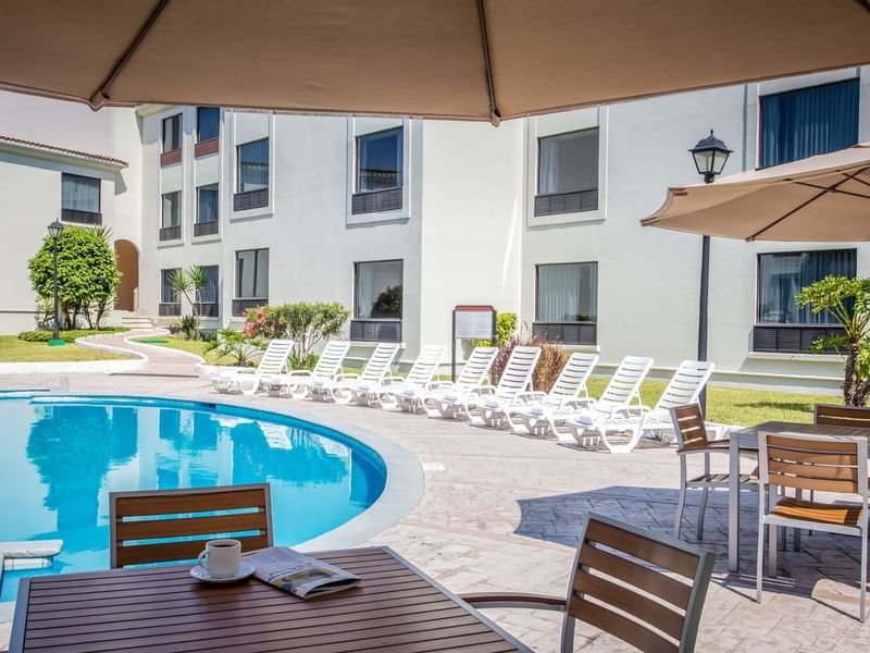 Sunbeds around an outdoor Swimming pool at Fiesta Inn Hotels