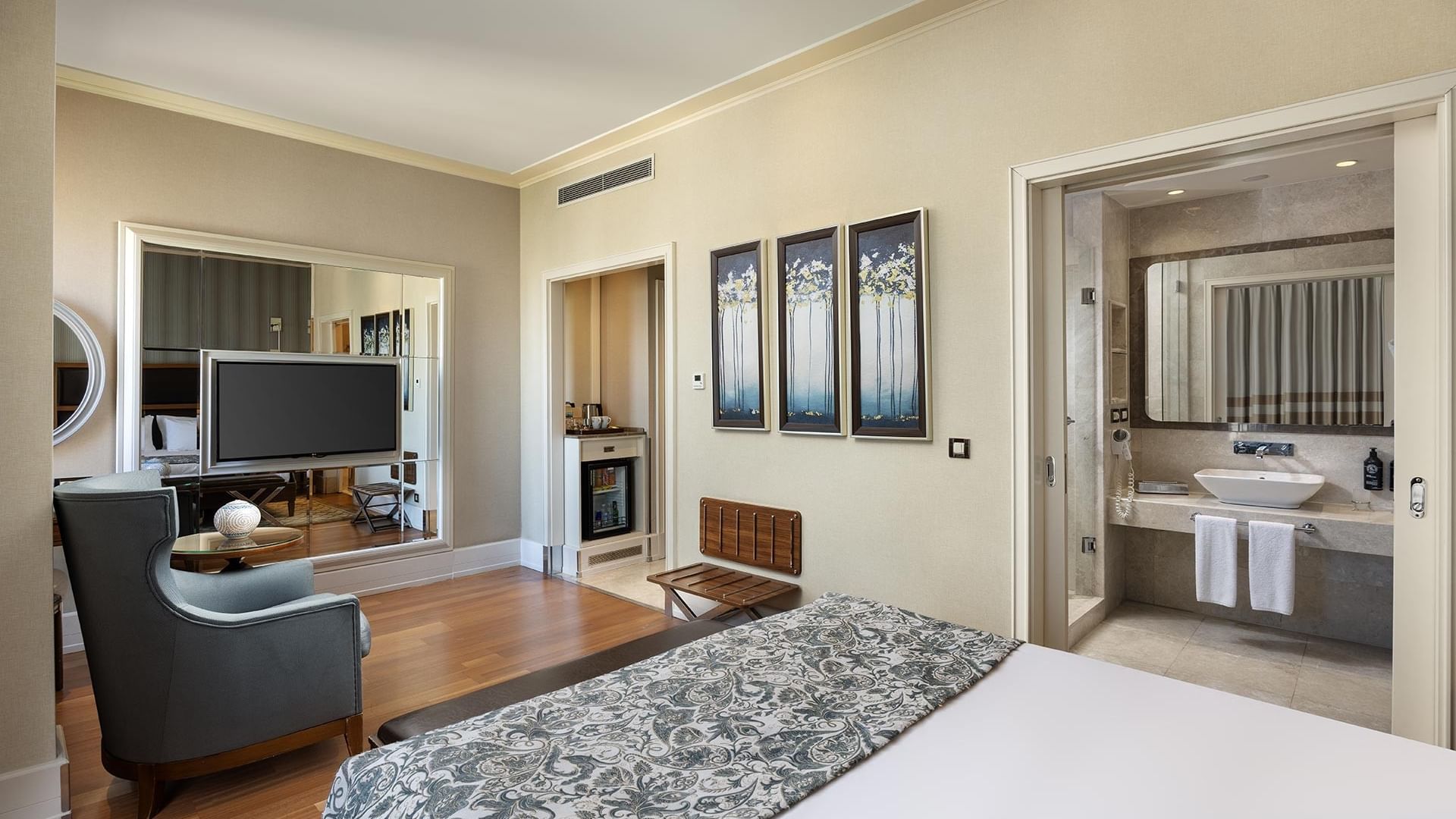 Titanic City Taksim'deki deluxe odadaki, yatak, sandalye, televizyon ve banyo.