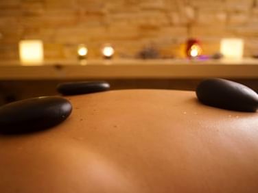 Hot Stone Massage on person in spa at NOI Puma Lodge Hotel
