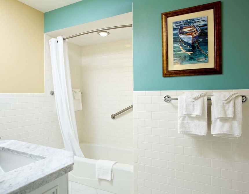 Bright bathroom with bathtub and wall-mounted artwork in Max Villas at Breezeway Boutique Hotel