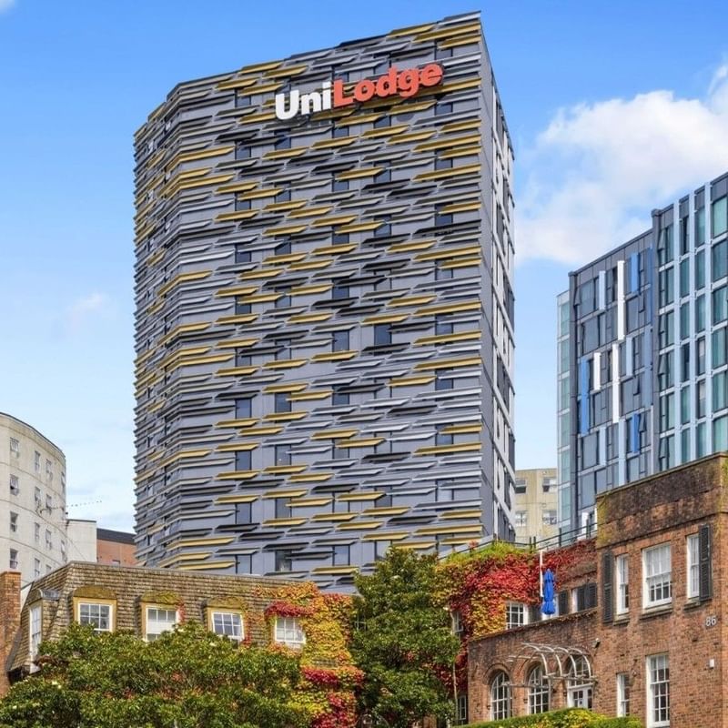 UniLodge building with unique facade design standing tall among other city buildings.