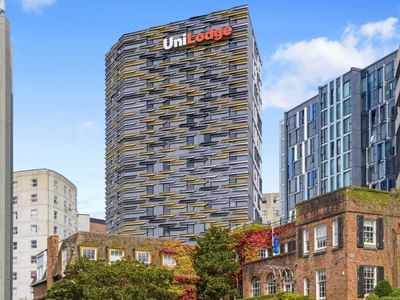 UniLodge building with unique facade design standing tall among other city buildings.