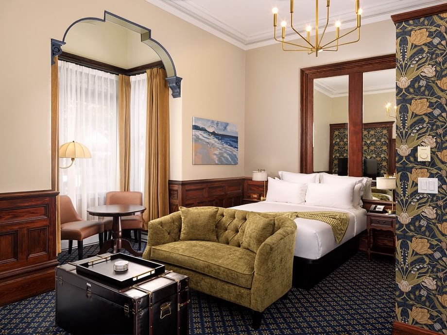 Elegant Camellia Room with ornate archway, plush seating, and dark wood furnishings at Belleville House, Pendray Inn Collection, Victoria.