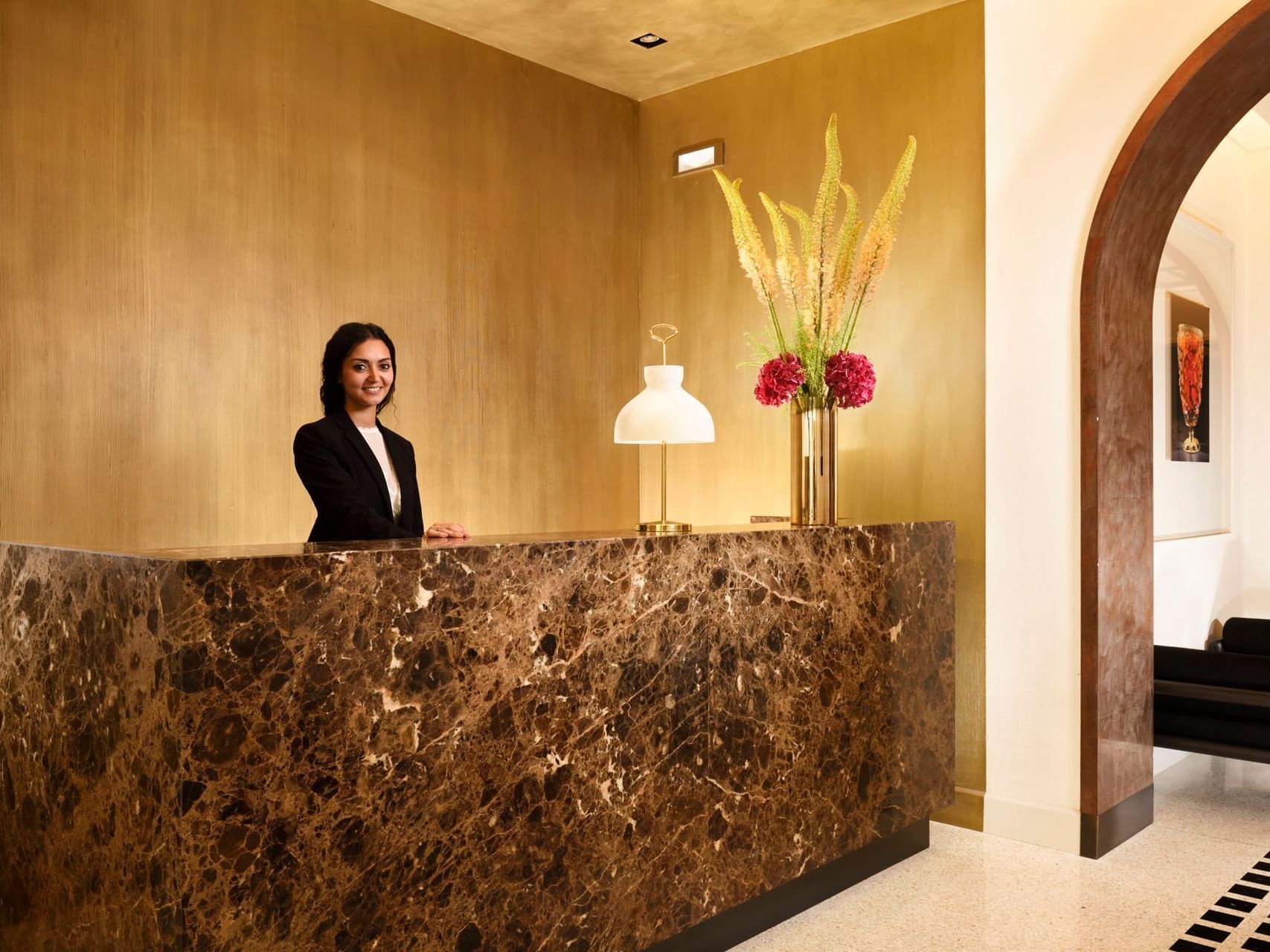 Receptionist by illuminated reception area with flower deco at Margutta 19