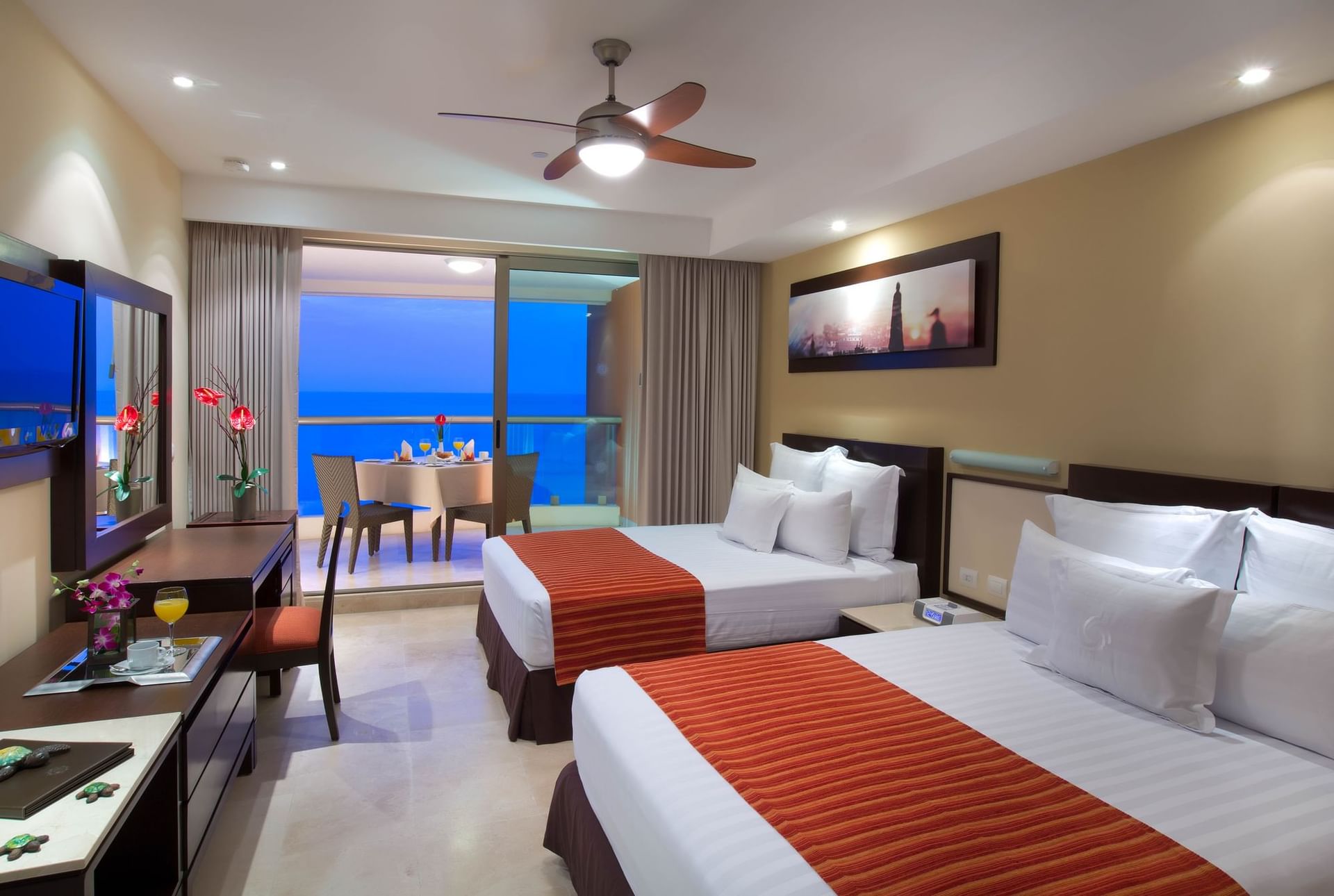 Foto de habitación de hotel con dos camas king-size, balcón con vistas al mar, zona comedor y decoración elegante en el Sunset Plaza Beach Resort