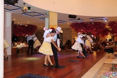 Dancers in white dresses and black suits performing on polished wooden floor at Playa Los Arcos Puerto Vallarta 2023