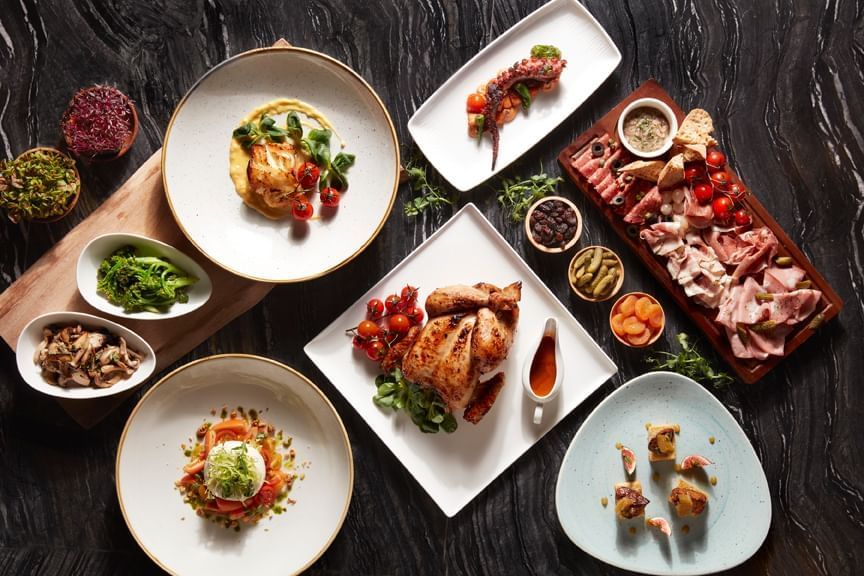 Table full with tempting food in Verandah Rooftop Rotisserie at Momentus Hotel Alexandra