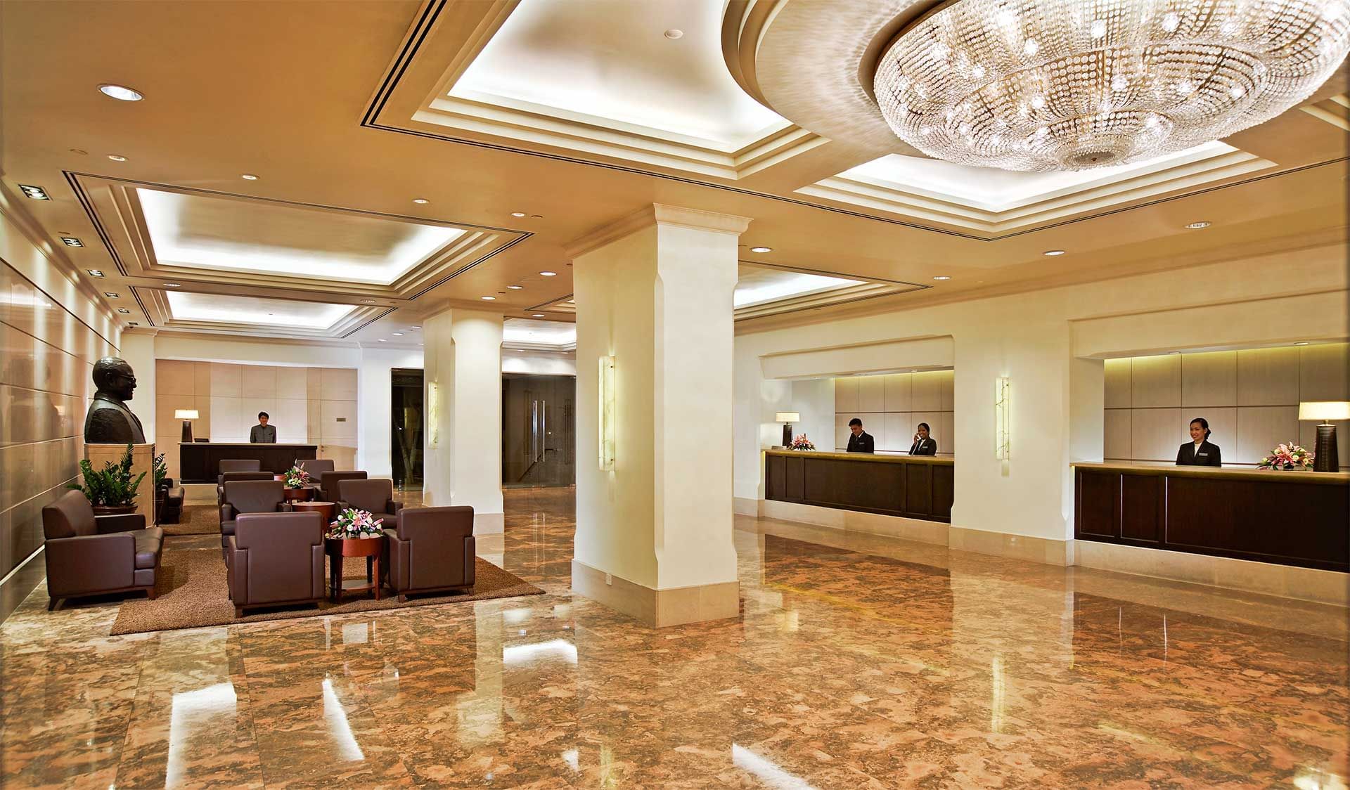 Image 37: Reception desk by the lobby lounge area with a large chandelier in York Hotel Singapore