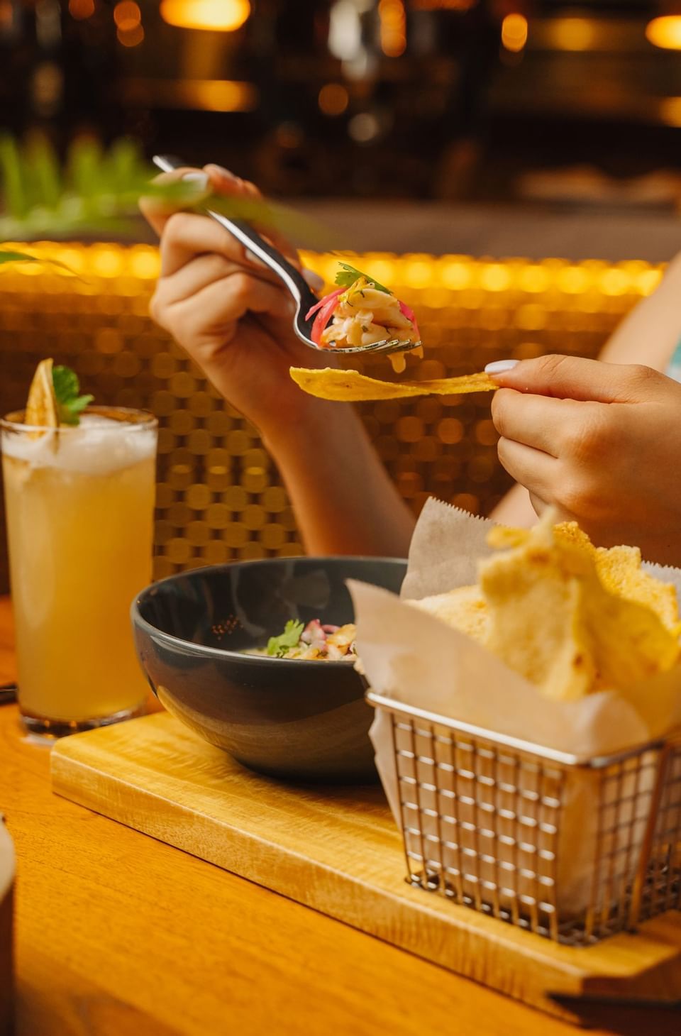 Hand holding a fork with food above a bowl in Bazul at Indura Beach & Golf Resort