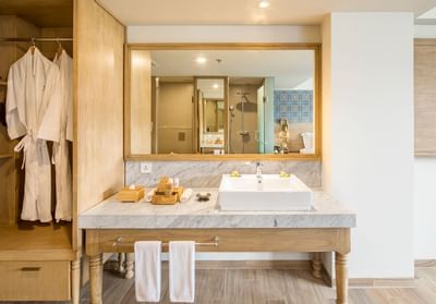 Bathroom with robes in Deluxe Room at Eastin Ashta Resort Canggu