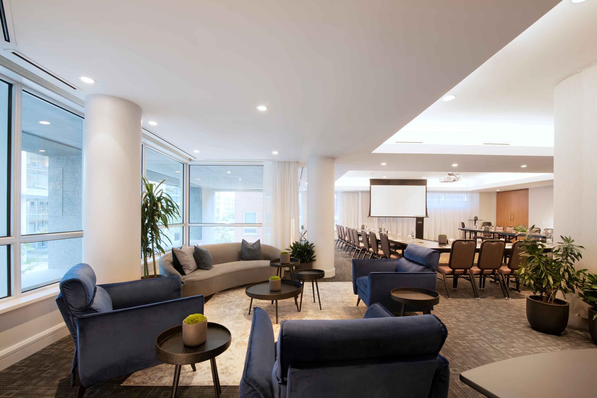 Salon Crescent and lounge area with a projector screen and a cozy seating space at Warwick Hotels and Resorts