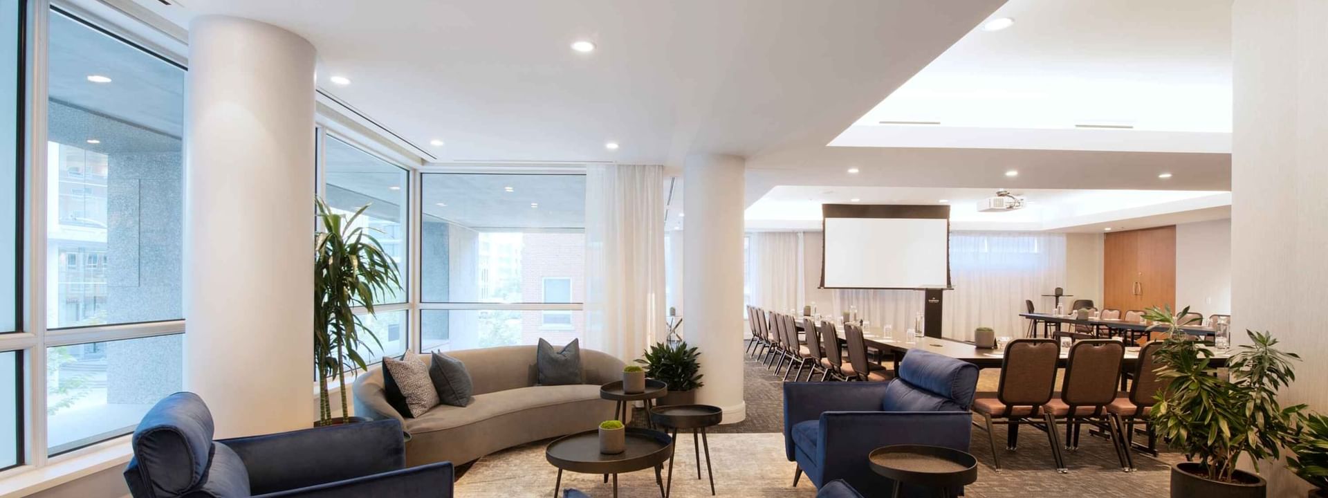 Salon Crescent et espace lounge avec écran de projection et sièges confortables à Warwick Hotels and Resorts