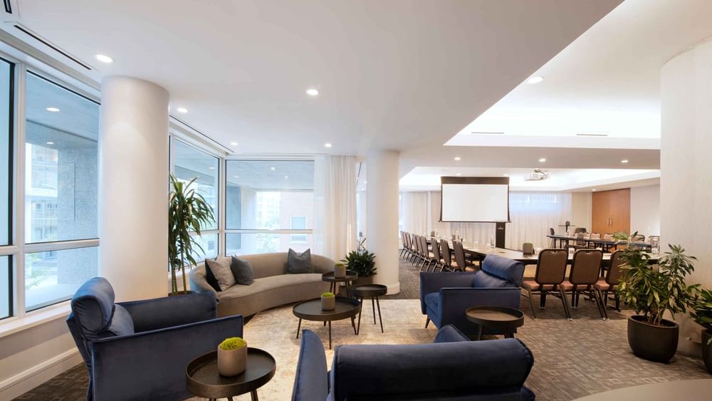 Salon Crescent et espace lounge avec écran de projection et sièges confortables à Warwick Hotels and Resorts