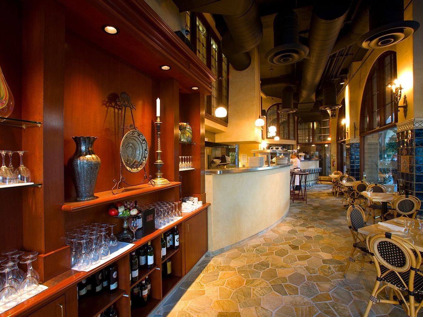 walkway in restaurant with tables and wine on shelves