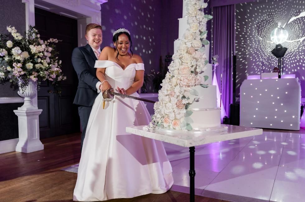 Bride and groom cutting cake at Easthampstead Park one of the best wedding venues in Wokingham