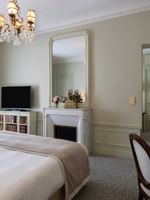 Elegant Deluxe Suite Parisienne with fireplace and chandelier at Hôtel Westminster Paris.
